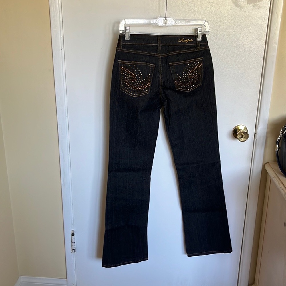 Dark wash Jean with embellished back pockets.